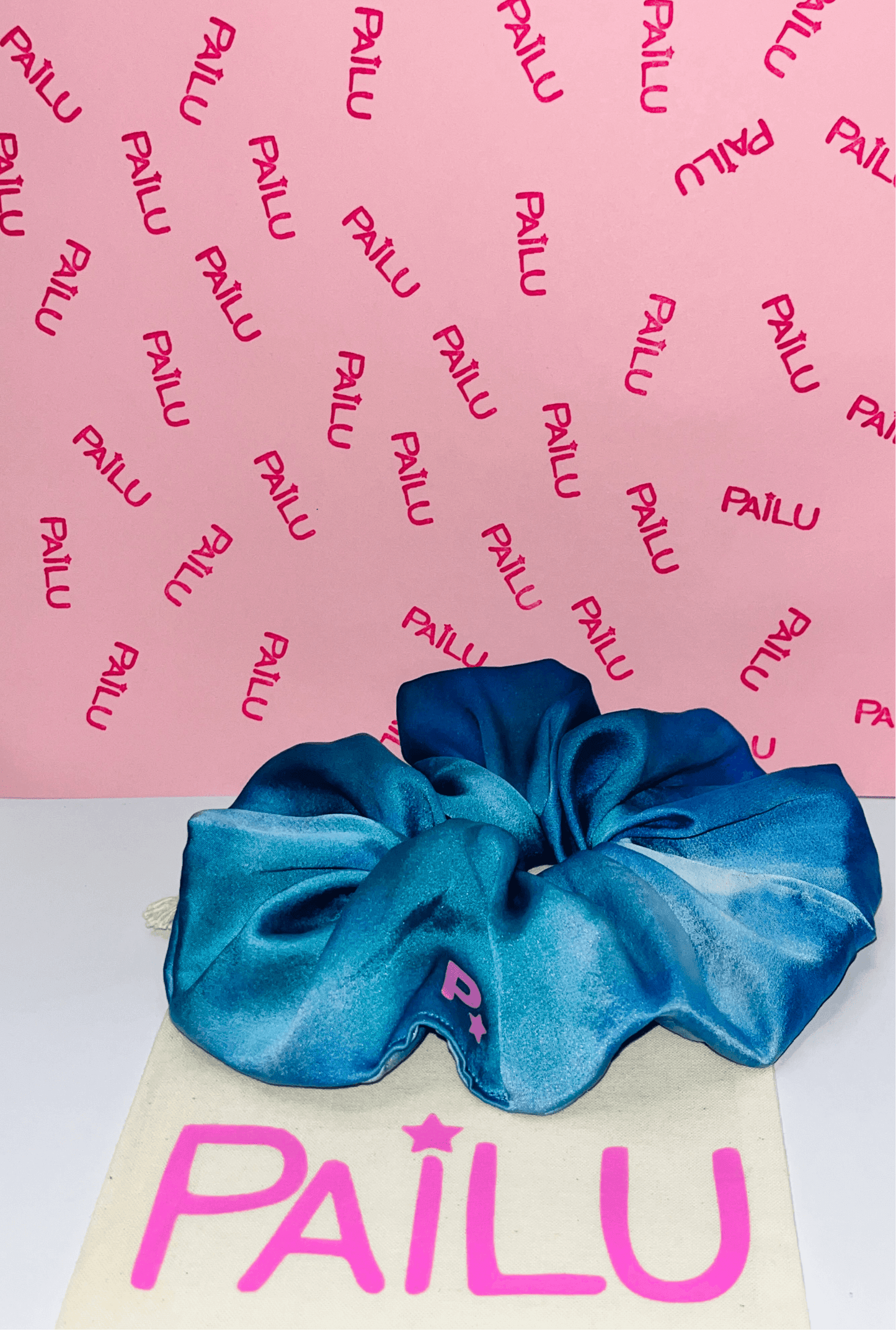 100% handmade stretch silk scrunchie in multi blue dye design displayed with included dustbag